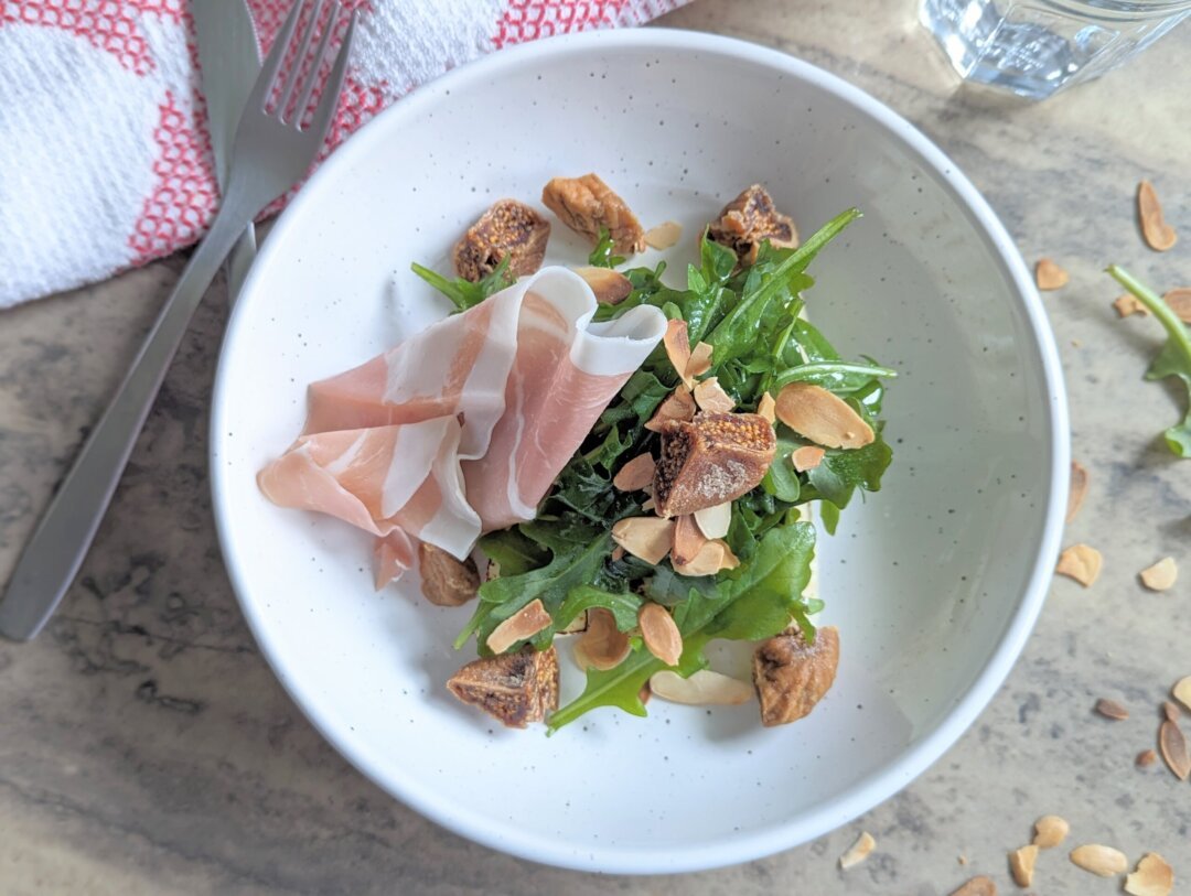 Salad with arugula, proscuitto, almonds, dried figs, and halloumi.